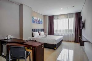 Tempat tidur dalam kamar di PrimeBiz Hotel Surabaya