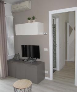 ein Wohnzimmer mit Fernseher und Sessel in der Unterkunft Sole di Lazise in Lazise