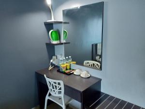 a black desk with a mirror and a white chair at G Langkawi Motel in Kuah