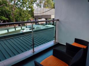 a balcony with two chairs and a bath tub on it at G Langkawi Motel in Kuah