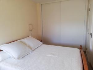 una piccola camera da letto con un letto con lenzuola bianche di luis 211 a Bajamar