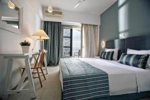 a bedroom with a bed and a desk and a window at Rigas Boutique Hotel & Spa in Afitos