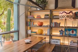 Habitación con mesa de madera y estante para libros. en The Corner House, en Sevilla