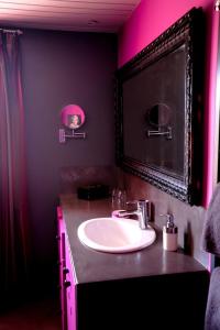 baño con lavabo y luz rosa en La Villa Léa, en Uzès