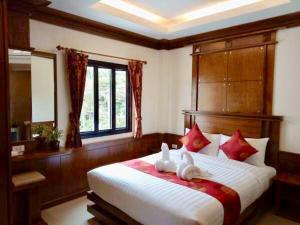 Un dormitorio con una gran cama blanca con almohadas rojas. en Lanta White’s House, en Ko Lanta