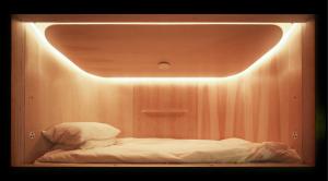 a room with a bed with a light above it at SLEEEP HKG Gough St in Hong Kong