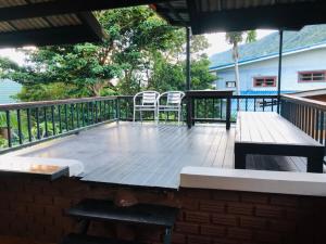 eine Terrasse mit 2 Stühlen und einem Tisch auf einer Terrasse in der Unterkunft Petit Suncliff Resort in Haad Rin