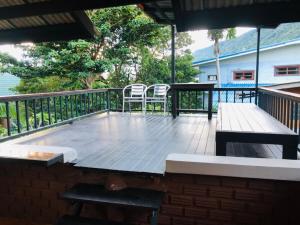 Un patio con dos sillas y una mesa en una terraza. en Petit Suncliff Resort, en Haad Rin