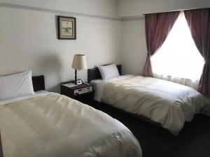 pokój hotelowy z 2 łóżkami i oknem w obiekcie Hotel Tsukuba Hills Umezono w mieście Tsukuba