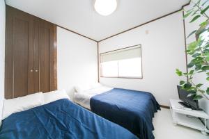 Una cama o camas en una habitación de Miraie Yokkaichi Kitahamacho