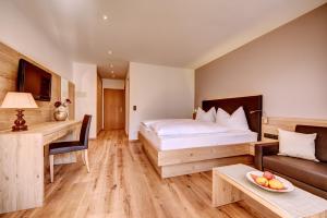 1 dormitorio con cama, sofá y mesa en Hotel Lamm, en Naturno