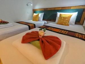 a hotel room with two beds with a flower on the bed at Lanta at Home - SHA Extra Plus in Ko Lanta