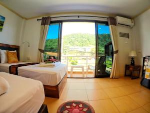 a hotel room with two beds and a balcony at Lanta at Home - SHA Extra Plus in Ko Lanta