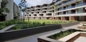 an apartment building with a garden in the foreground at Ocean Dune Studio in Sibaya