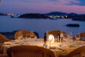 a dinner table with wine glasses and a view of the water at Hotel Bendinat in Portals Nous