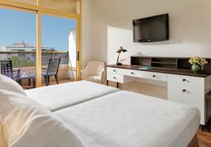 a hotel room with two beds and a television at H10 Salou Princess in Salou