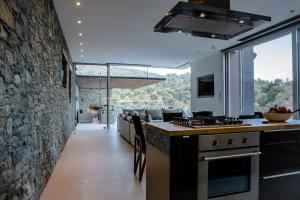 a kitchen with a stone wall and a counter at Infinity Villa in Plomarion