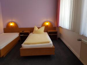 a hotel room with two beds and two windows at Hotel-Cafe am Rathaus in Gardelegen