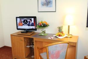 a desk with a computer on top of a room at Hotel Weisser Schwan in Erfurt