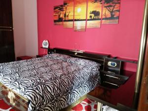 una camera con letto e parete rosa di La Romantica a Randazzo