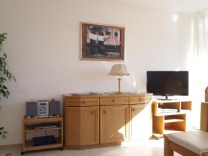 ein Wohnzimmer mit einem TV auf einem Holzschrank in der Unterkunft Ferienwohnung Schimmer in Braunlage