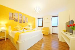 a bedroom with a large white bed and a television at San Marco Apartment Fabbri in Venice