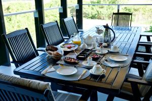 einem Holztisch mit Tellern und Schalen mit Lebensmitteln darauf in der Unterkunft Normarie's Guesthouse in Wilderness
