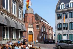 een groep mensen die aan tafel zitten in een stadsstraat bij Urban Residences Maastricht in Maastricht