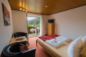 a bedroom with a bed and a table and a window at Pension Himmelreich in Glatt