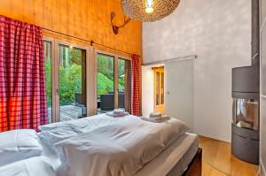 een slaapkamer met een bed en een groot raam bij Charming Little Chalet for 6 People & Free Ski Lockers in Grindelwald
