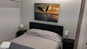 sypialnia z łóżkiem i obrazem na ścianie w obiekcie Cozy one bedroom apartment near Auckland Airport w Auckland