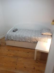 ein kleines Bett in einem Zimmer mit einem Tisch in der Unterkunft San Sebastián Hideaway in San Sebastián