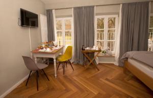 a bedroom with a table and chairs and a bed at Bed and Breakfast unter den Linden in Nördlingen