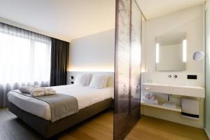 Cette chambre comprend un lit et un lavabo. dans l'établissement R hotel experiences, à Sougné-Remouchamps