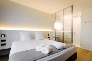 una camera da letto con un grande letto bianco con asciugamani di R hotel experiences a Sougné-Remouchamps