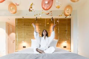 a woman sitting on a bed with balloons at R hotel experiences in Sougné-Remouchamps
