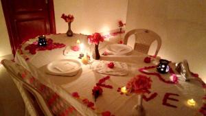 einen Tisch mit einem weißen Tischtuch mit Blumen darauf in der Unterkunft Skylarc Inn in Udagamandalam