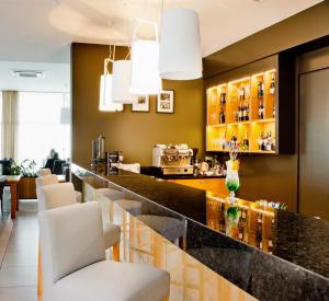 a bar in a restaurant with white chairs at Aroma Stone Hotel Spa in Syców