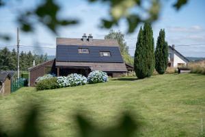 a house with a solar panel on top of a yard at Aux 4 chalets in Bouillon