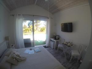 a bedroom with a bed and a tv and a window at Villa Saint Barth in Gujan-Mestras