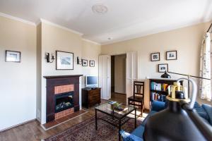a living room with a fireplace and a blue couch at Landhaus Piber in Piber