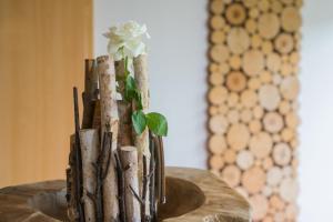 a vase with a flower on top of a table at Pension Himmelreich in Glatt