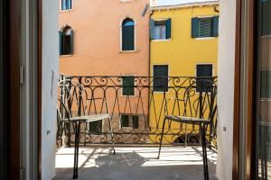 a balcony with two chairs and a building at Liassidi Arco in Venice