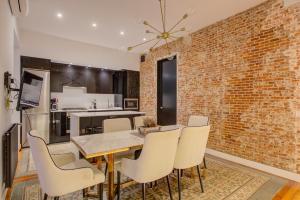 jadalnia z ceglaną ścianą oraz stołem i krzesłami w obiekcie Luxury Rooms Madrid Center w Madrycie