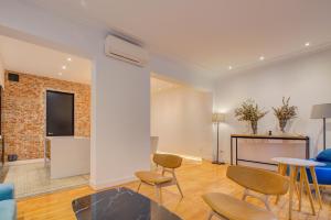 a living room with chairs and a table and a tv at Luxury Rooms Madrid Center in Madrid