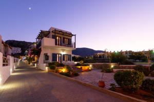 a large white building with a pathway in front of it at Okirroi Villas Chersonissos in Hersonissos