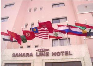un grupo de banderas internacionales volando sobre un hotel de la línea Santa Clara en Sahara Line Hotel, en Laayoune