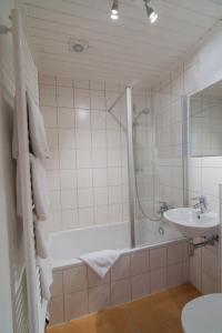 a bathroom with a bath tub and a sink at Pension Himmelreich in Glatt