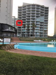 einem Pool vor einem großen Gebäude in der Unterkunft 501 Beach Club in Mossel Bay