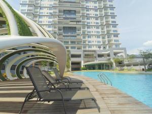 a group of chairs sitting next to a swimming pool at Puchong Skypod Residence, 1-5 pax Cozy Unit, Walking Distance to IOI Mall, 10min Drive to Sunway in Puchong